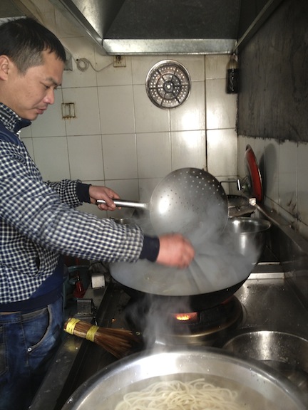 Then the laoban, or boss, cooked the noodles in boiling water. He cooled them quickly, no more than a minute, and immediately threw them in a bowl of cold water. (Which you can see at the bottom of the picture.)